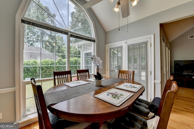 dining area featuring wood finished floors, a ceiling fan, and high vaulted ceiling