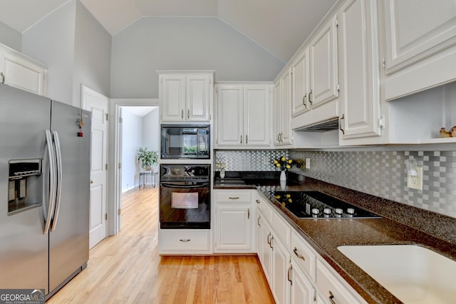 kitchen featuring black appliances, white cabinetry, decorative backsplash, light wood-style flooring, and vaulted ceiling