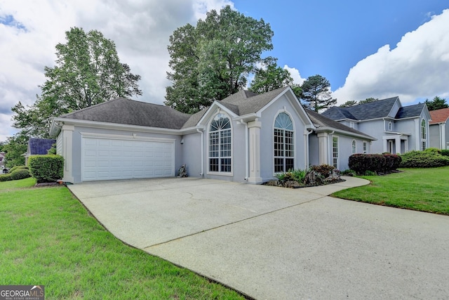 single story home featuring stucco siding, driveway, an attached garage, and a front yard