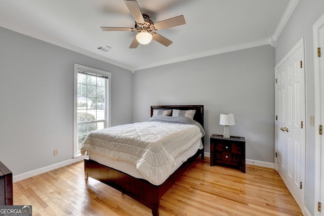 bedroom featuring ornamental molding, light wood-type flooring, baseboards, and ceiling fan