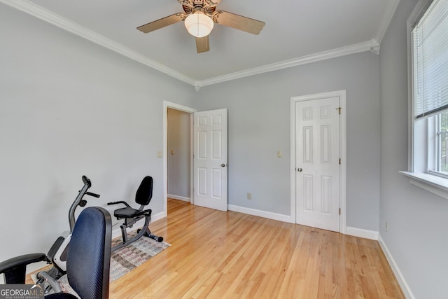 home office with light wood finished floors, ornamental molding, a ceiling fan, and baseboards