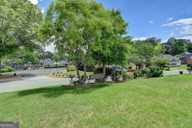 view of green lawn with a residential view