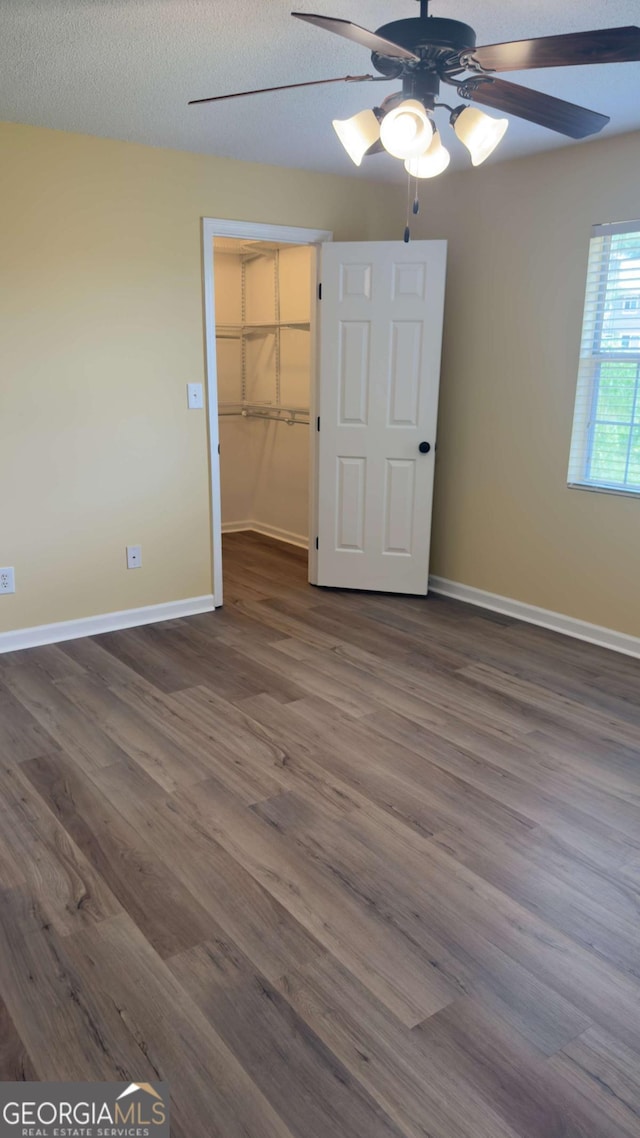 138 Tamara Ct, Athens, GA 30606 - unfurnished bedroom with baseboards, dark wood finished floors, a ceiling fan, a closet, and a spacious closet