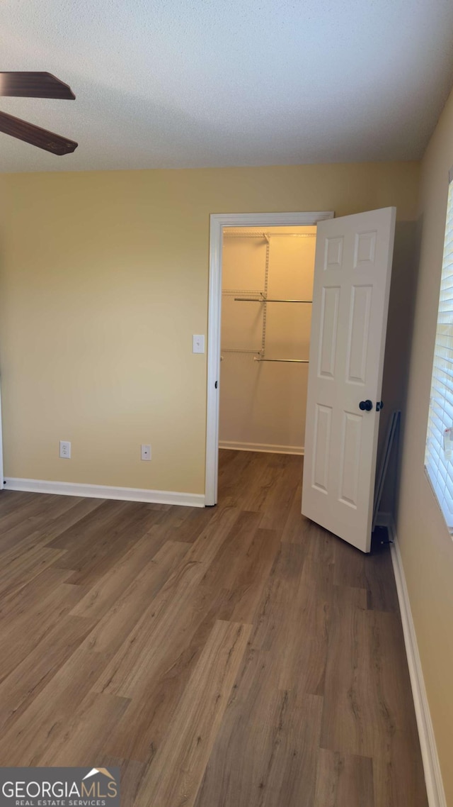 138 Tamara Ct, Athens, GA 30606 - unfurnished bedroom featuring wood finished floors, a spacious closet, and baseboards