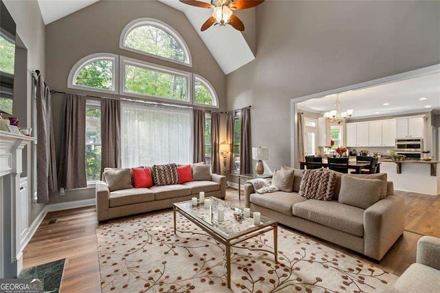 3705 Rolling Creek Dr, Buford, GA 30519 - living room featuring a chandelier, light wood-style flooring, high vaulted ceiling, and a ceiling fan