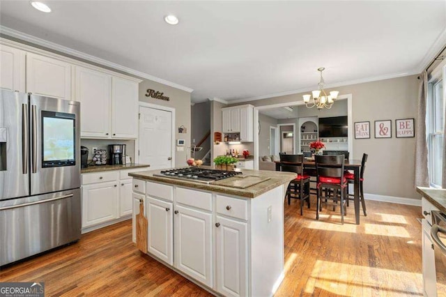 3705 Rolling Creek Dr, Buford, GA 30519 - kitchen with stainless steel appliances, a chandelier, a kitchen island, crown molding, and white cabinets