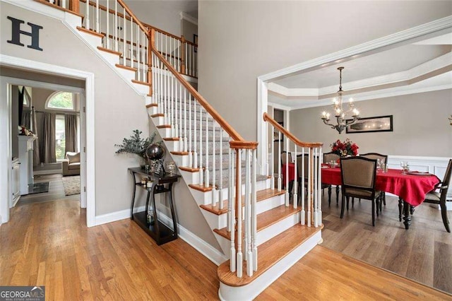 3705 Rolling Creek Dr, Buford, GA 30519 - stairs featuring wood finished floors, a chandelier, crown molding, and baseboards