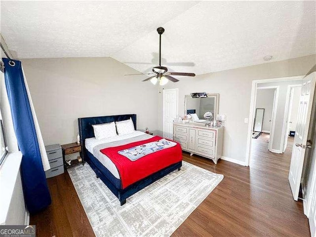 6092 Leverett Dr, Lithonia, GA 30038 - bedroom featuring a textured ceiling, dark wood-style flooring, vaulted ceiling, ceiling fan, and baseboards