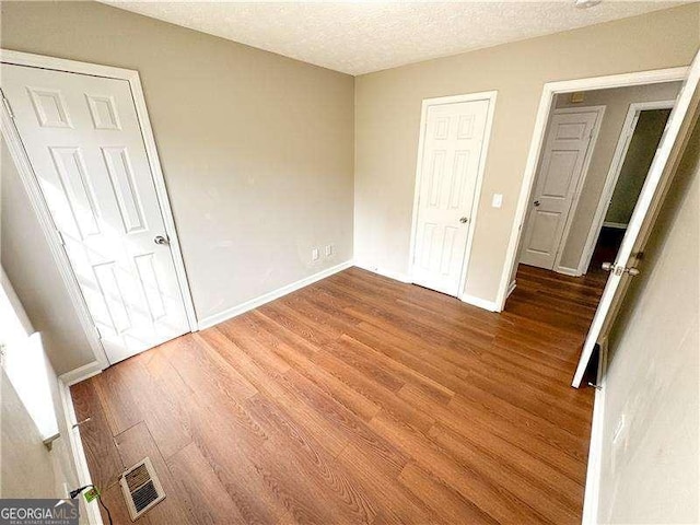 6092 Leverett Dr, Lithonia, GA 30038 - unfurnished bedroom with wood finished floors, baseboards, and a textured ceiling