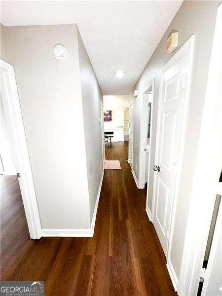 6092 Leverett Dr, Lithonia, GA 30038 - hallway with baseboards and dark wood finished floors