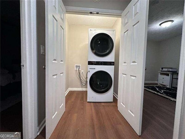 6092 Leverett Dr, Lithonia, GA 30038 - washroom with stacked washer and clothes dryer, wood finished floors, and baseboards