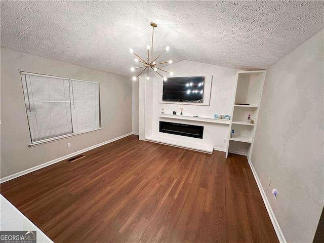 6092 Leverett Dr, Lithonia, GA 30038 - unfurnished living room featuring wood finished floors, a chandelier, a textured ceiling, vaulted ceiling, and a fireplace