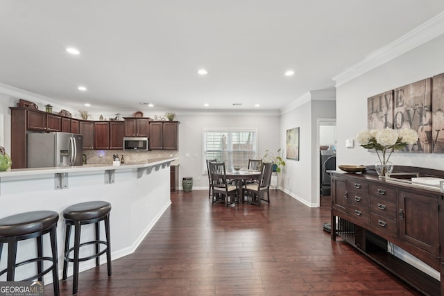 1840 Brighton Blvd SE, Atlanta, GA 30316 - kitchen featuring appliances with stainless steel finishes, a breakfast bar, light countertops, ornamental molding, and dark wood-style floors