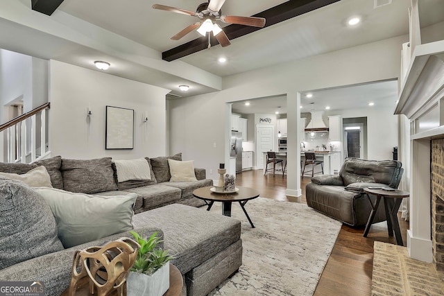living room with ceiling fan, beam ceiling, dark wood-style flooring, stairs, and recessed lighting