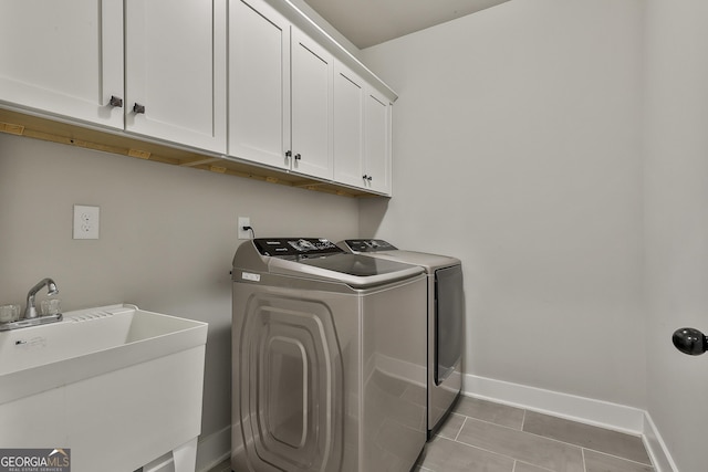 laundry area with cabinet space, washer and dryer, baseboards, and light tile patterned floors