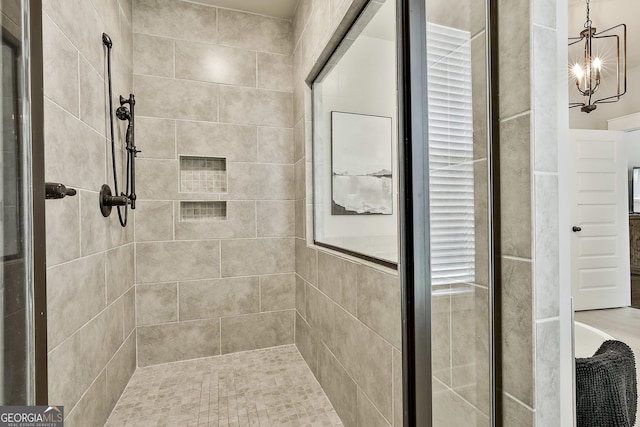 full bathroom with a shower stall and a chandelier