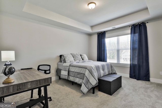 bedroom featuring a raised ceiling, baseboards, and light colored carpet