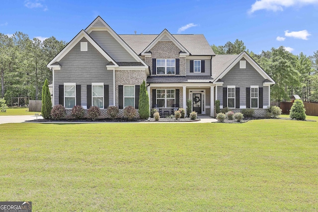 craftsman inspired home featuring a shingled roof and brick siding