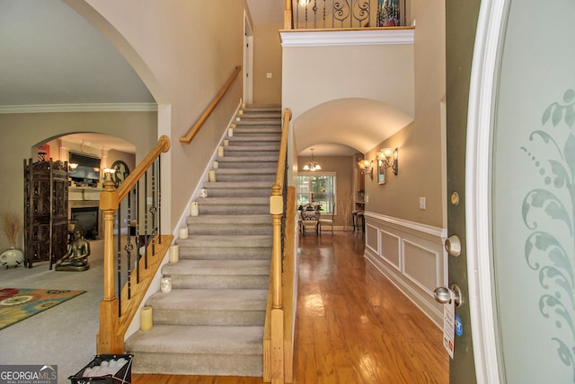 4765 Smokestone Dr, Douglasville, GA 30135 - foyer entrance featuring arched walkways, stairway, a wainscoted wall, a chandelier, and ornamental molding