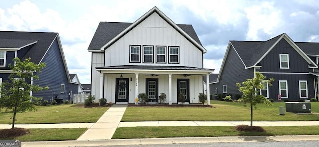 modern farmhouse style home with board and batten siding, a porch, ceiling fan, and a front yard