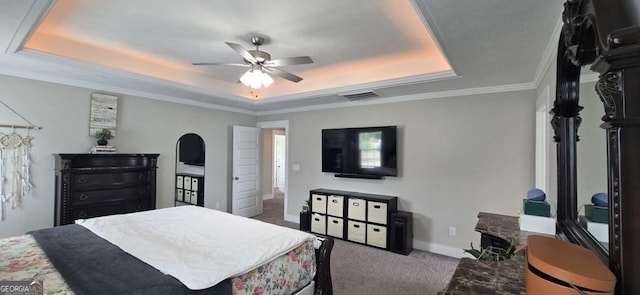 bedroom with a raised ceiling, carpet floors, baseboards, crown molding, and ceiling fan