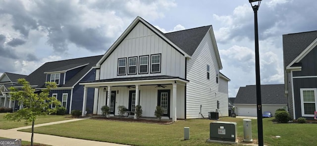 modern farmhouse with board and batten siding, a ceiling fan, a porch, and a front lawn