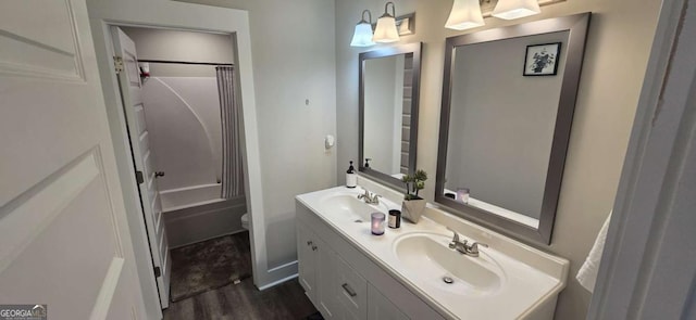 bathroom with double vanity, wood finished floors, shower / tub combo, and toilet