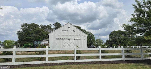 view of pole building featuring fence and driveway