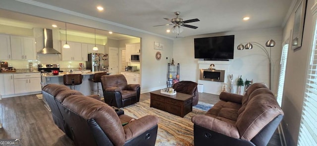 living room with a ceiling fan, wood finished floors, recessed lighting, and crown molding