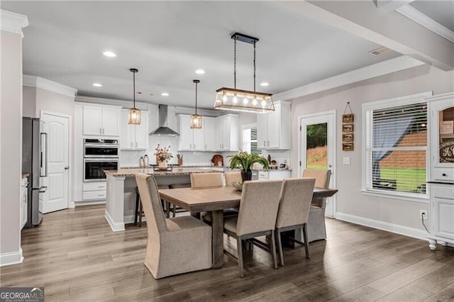 dining room with crown molding, recessed lighting, wood finished floors, and baseboards