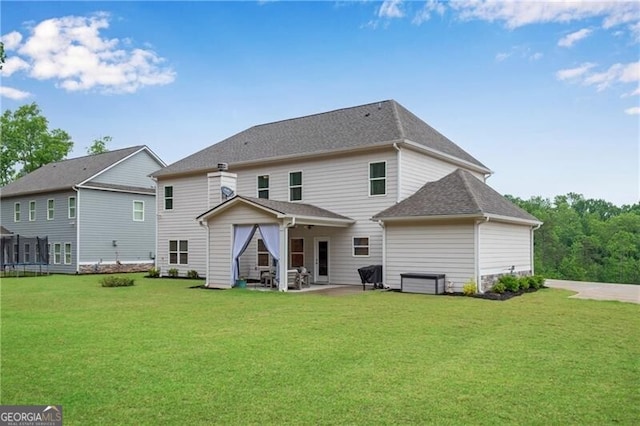 rear view of property with a lawn, a patio, and a shingled roof