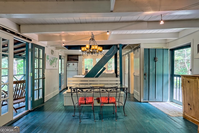 dining space with beam ceiling, a chandelier, and wood-type flooring