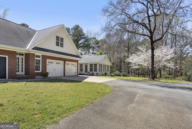 5695 Sweetbriar Trl, Macon, GA 31210 - view of property exterior featuring driveway, a lawn, brick siding, roof with shingles, and french doors
