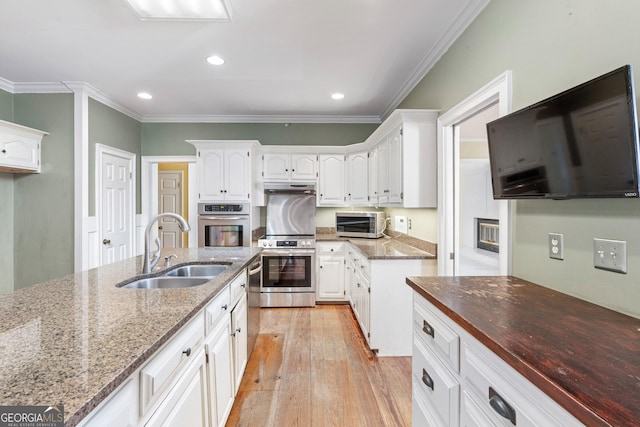 5695 Sweetbriar Trl, Macon, GA 31210 - kitchen featuring a sink, stainless steel appliances, light stone counters, white cabinets, and recessed lighting