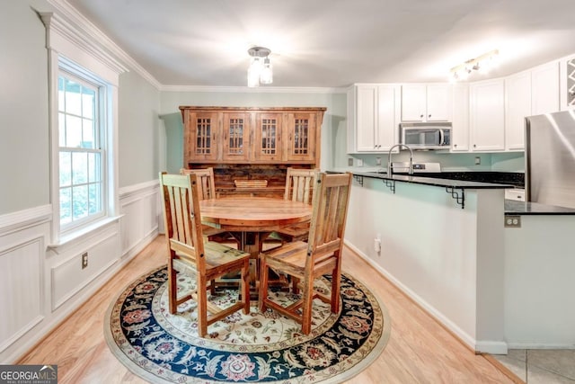 1445 Monroe Dr NE Unit F18, Atlanta, GA 30324 - dining area with light wood-style flooring, wainscoting, and crown molding