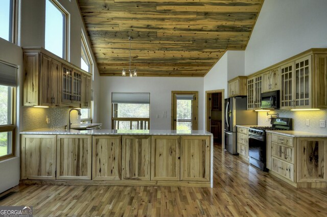 kitchen featuring appliances with stainless steel finishes, high vaulted ceiling, wooden ceiling, a sink, and a peninsula