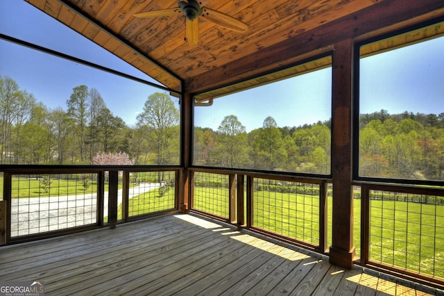 wooden deck with a ceiling fan and a forest view