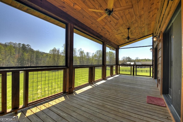 unfurnished sunroom featuring a ceiling fan and lofted ceiling