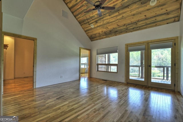 unfurnished living room featuring plenty of natural light, high vaulted ceiling, wood finished floors, a ceiling fan, and french doors