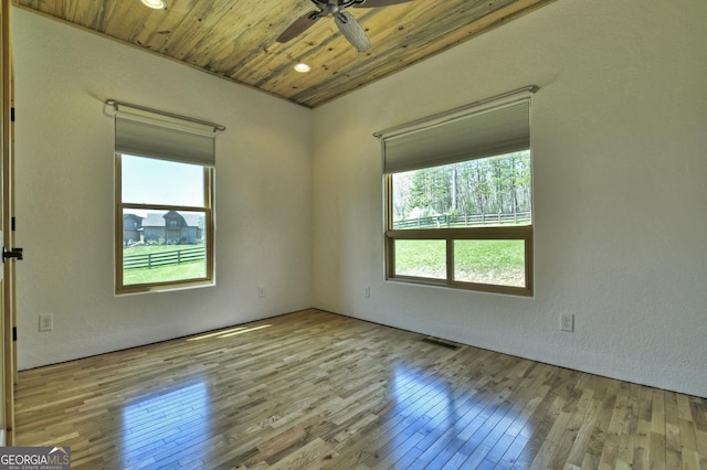empty room with a ceiling fan, hardwood / wood-style flooring, and wood ceiling