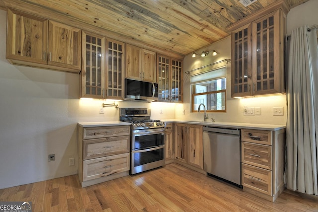 kitchen featuring stainless steel appliances, wooden ceiling, a sink, glass insert cabinets, and light countertops