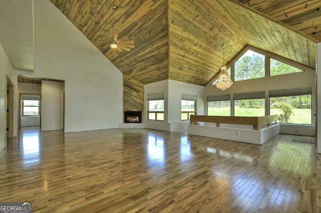 unfurnished living room with high vaulted ceiling, hardwood / wood-style floors, healthy amount of natural light, wood ceiling, and a high end fireplace