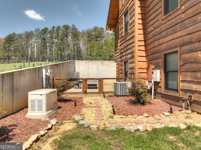 view of yard featuring central AC and fence