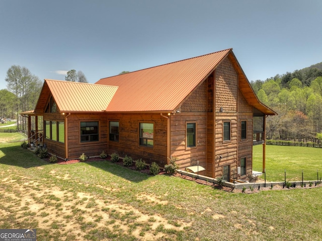 rear view of house with a yard and metal roof