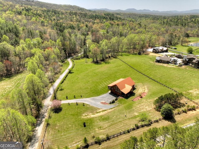 aerial view of sparsely populated area featuring a forest and mountains