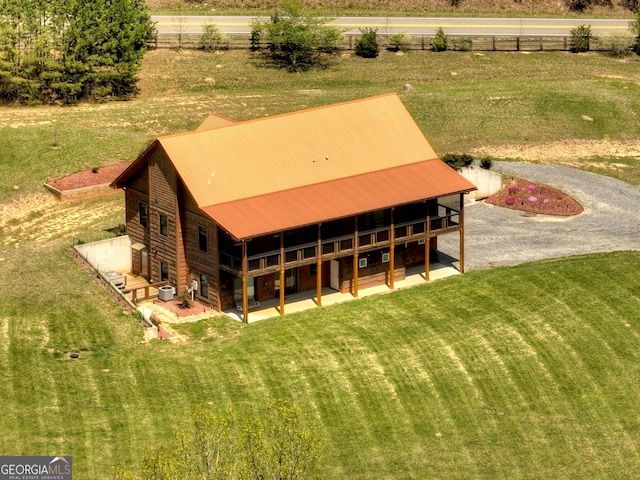 rear view of property with a patio area, metal roof, a yard, and central AC