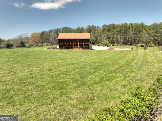 view of green lawn with a wooded view