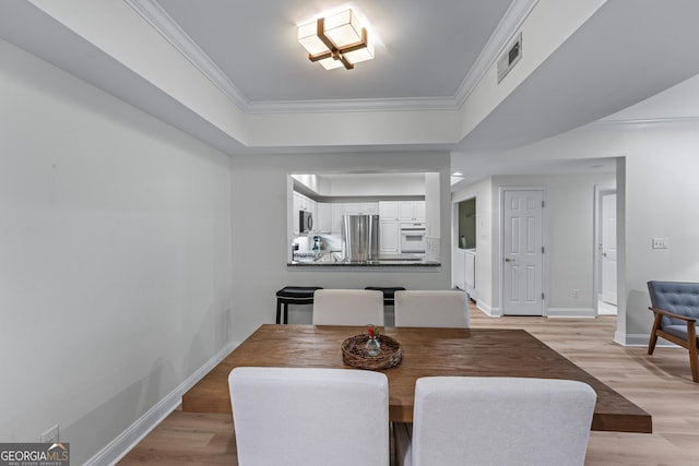 3636 Habersham Rd NW Unit 2101, Atlanta, GA 30305 - dining space featuring light wood finished floors, baseboards, ornamental molding, and a tray ceiling