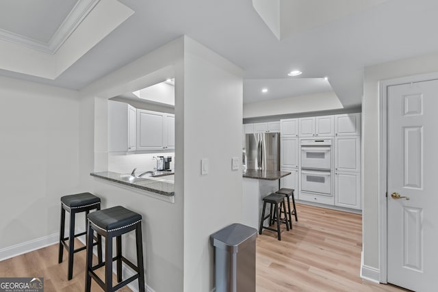 3636 Habersham Rd NW Unit 2101, Atlanta, GA 30305 - kitchen featuring a kitchen breakfast bar, freestanding refrigerator, double oven, white cabinetry, and recessed lighting
