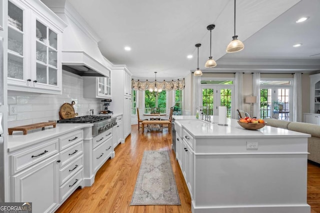 kitchen with white cabinetry, healthy amount of natural light, light countertops, recessed lighting, and crown molding